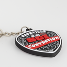 A novelty keychain shaped like a guitar pick, featuring the text 'Nashville SCI Convention' in white and red on a black and red background, attached to a silver metal keychain on a light gray background.